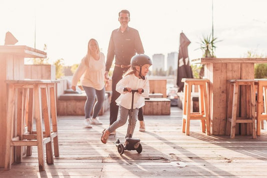 girl on a scooter with her parents