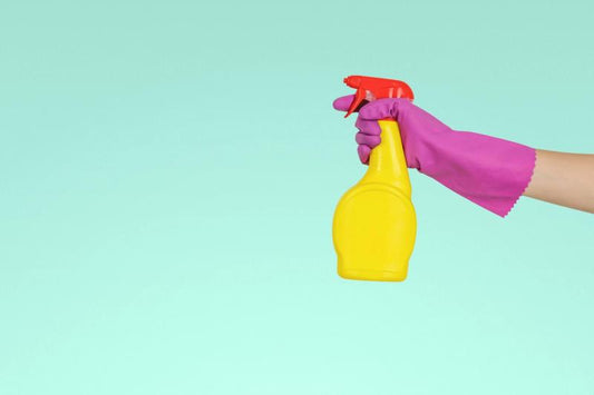 purple glove with a yellow spray bottle